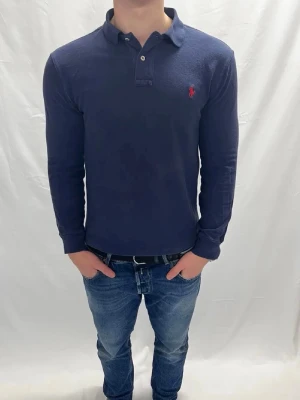 Ralph Lauren piké  - Tjena säljer en mörkblå navy långarmad piké från Ralph Lauren. Storlek 14-16 som motsvarar ca xs. Pikén är fåtal gånger använd och därefter inga defekter. Det är bara att höra av er vid frågor eller funderingar😊🙌