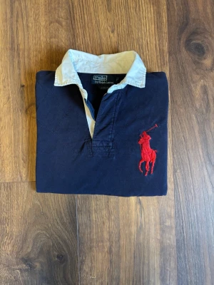 Mörkblå Ralph Lauren pike - Klassisk mörkblå pike från ralph lauren. Tröjan är i jätte bra skick och jag använder den inte för den är för stor på mig
