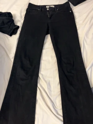 Svarta bootcut jeans - Säljer ett par svarta bootcut jeans med klassisk femficksdesign. Jeansen har utsvängda ben och hög midja, perfekta för en trendig och avslappnad look. Materialet är mjukt och stretchigt för extra komfort.