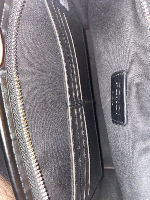 Svart plånbok från Fendi - Snygg svart axelväska från Fendi med dragkedja och flera kortfack. Tillverkad i ett tåligt tygmaterial med diskret Fendi-logga på insidan. Perfekt för dig som vill ha en stilren och exklusiv accessoar.