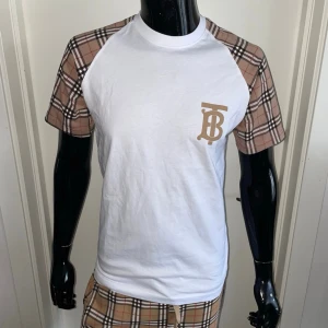Burberry T-Shirt, Vit, Storlek XL - Helt ny, högkvalitativ replika Skyltdockan  på bilderna är 175 cm lång och bär storlek S.  Pris: 899 kr  Leverans: Skickas inom 24 timmar  Observera: Begränsat antal i lager – först till kvarn gäller  