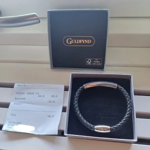 Svart flätat armband från Guldfynd - Snyggt svart flätat armband från Guldfynd med detaljer i blankt stål. Med carbon filter Inlay