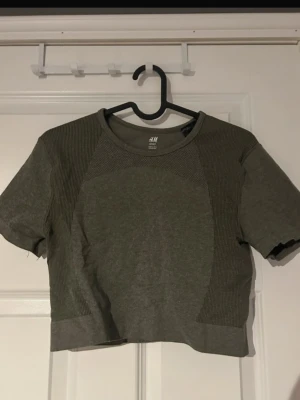 Träningstopp  - Snygg croppad träningstopp från H&M med rund halsringning och korta ärmar,  är tillverkad i ett mjukt material som sitter tight och bekvämt mot kroppen.(ifrån h&m) 