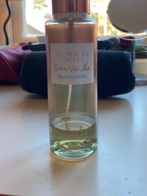 Bare Vanilla Sunkissed mist 250ml - Fräsch och trendig body mist från Victoria's Secret. 250 ml. På flaskan står: Vanilla Glimmer, Amber Beams, Bare Vanilla Sunkissed. Perfekt för dig som vill ha en lätt och ungdomlig doft.