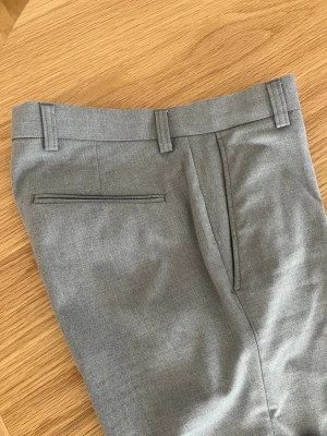 Snygga gråa chinos i strl W28/30 - Gråa chinos/kostymbyxor i storlek W28/30 i slim fit och riktigt fint skick.