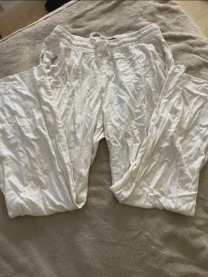 Vita linnebyxor från 157 - Vita linnebyxor från 157 med avslappnad passform och resår i midjan. Tillverkade i ett lätt och luftigt material som känns skönt mot huden. Perfekta för en chill och enkel stil.