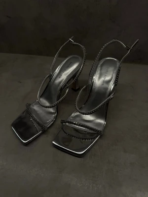 Marc Fisher silver heels - statement  - Marc Fisher klackar i silver med snygga & enkla kedjedetaljer - perfekta för att klä upp en outfit eller för utgång 🤍  Använda ca 3-4 gånger, fint skick✨  Klackhöjd: ca 10cm ⚡️  Storlek: US 8.5 / EU 39