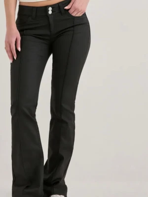 Svarta coated low waist jeans Nelly - Snygga svarta coated jeans från Nelly med låg midja och raka ben. Jeansen har två knappar i midjan och markerade sömmar framtill för en cool look. Perfekta för dig som gillar trendiga och stilrena byxor.