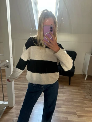 Randig stickad tröja i svart och vit - Snygg stickad tröja med breda svarta och beige ränder. Från H&M i storlek XS/34 i bra skick. Nypris 349kr