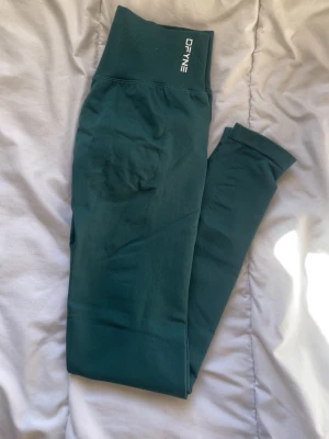 Gröna Impact leggings DFYNE - Snygga gröna seamless leggings från DFyne med hög midja och scrunch-detalj bak. Mjukt och stretchigt material som sitter skönt och formar sig efter kroppen. Perfekta för träning eller chill.