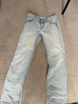Ljusblå baggy jeans - Säljer ett par ljusblå jeans med baggy passform. Säljer då de är lite för små på mig som man ser på bilden. Jeansen sitter jättebra bortsett från de och är en jättefin ljusblå färg. Säljer lite billigare pga mindre slitningar nere vid benen men inga större problem än så!💞