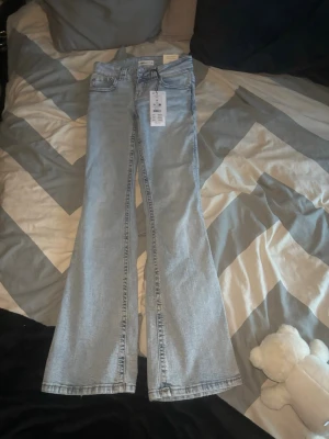 Ljusblå bootcut jeans från Perfect Jeans - Säljer ett par ljusblå bootcut jeans från Perfect Jeans i modellen Y2K low bootcut. Jeansen har låg midja, klassisk femficksdesign och är tillverkade i denim. Perfekta för en trendig och avslappnad look.
