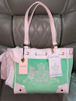 Juicy Couture daydreamer och rosa tote - Superfin handväska från Juicy Couture i pastellgrönt och ljusrosa med gulddetaljer. Väskan har broderad logga framtill, långa handtag och är gjord i mjuk velour med detaljer i konstläder. Perfekt för dig som gillar en söt och trendig look.