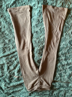 Beige utsvängda leggings - Snygga beige leggings med utsvängda ben och mjukt stretchigt tyg. Perfekta för dig som gillar en avslappnad men trendig look. Passar till både sneakers och boots. Inga synliga loggor eller detaljer.