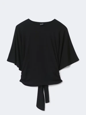 Svart topp med knytband från Gina Tricot - Snygg svart topp från Bik Bok med vida ärmar och knytband i midjan. Toppen har rund halsringning och är gjord i ett mjukt, stretchigt material som faller fint. Perfekt till jeans eller kjol för en trendig look.