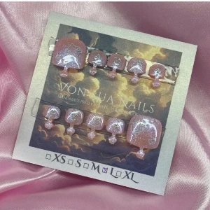 GlitterKitty (L);Square Toes - Handgjorda tå-press-on naglar i en rosa cateye nyans med glitter och vita HK motiv. Naglarna har en fyrkantig form och är dekorerade med skimrande detaljer som ger en unik och kreativ look. Perfekt för dig som vill ha något extra på naglarna.L: 17 mm, 10 mm, 10,5 mm, 10 mm, 8 mm 