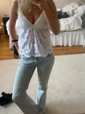 Gina tricot - sommartopp - Säljer en vit blus med v-ringning och broderade spetsdetaljer. Tröjan är från Gina och köpt förra sommaren 💕