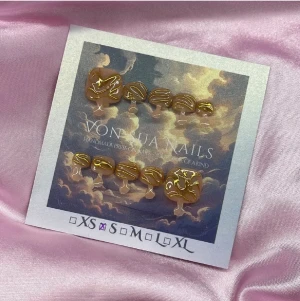 Goldie (S):Square Toes - Handgjorda toe-press-on naglar i brun bas med unika abstrakta mönster i guld. Naglarna har en kort, square form och är tillverkade i S: 14 mm, 9 mm, 9,5 mm, 9 mm, 6 mm. Perfekt för dig som vill ha en trendig och konstnärlig look på naglarna.