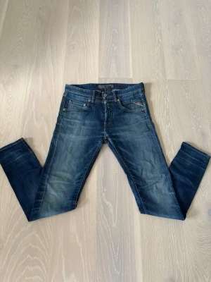 Blå jeans från Replay - Snygga blå jeans från Replay med klassisk femficksmodell och slitningar för en cool, använd look. Jeansen har normal midja, dragkedjegylf och är tillverkade i denim av bomull. Perfekta för dig som gillar en avslappnad men trendig stil. Vid intresse är det bara att höra av sig. Pris går att diskutera