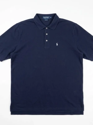 Mörkblå pikétröja från Polo Golf - Klassisk mörkblå pikétröja från Polo Golf Ralph Lauren med vit broderad logga på bröstet. Tröjan har krage, tre knappar framtill och korta ärmar. Perfekt för en stilren och sportig look.