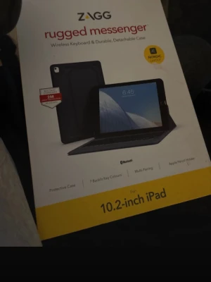 ZAGG rugged messenger tangentbord iPad - Trådlöst tangentbord och avtagbart skyddsfodral för 10.2-tums iPad. Svart färg, nordiskt tangentbord, Bluetooth, sju bakgrundsbelysta färger och Apple Pencil-hållare. Robust design i plast och gummi för extra skydd.