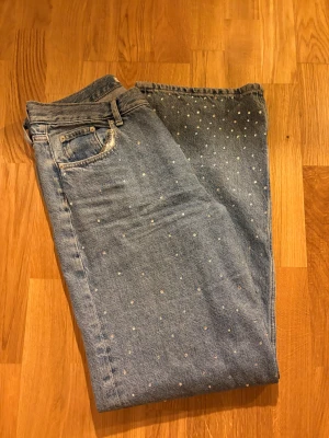 Jeans med blingstenar - Säljer ett par jeans från Gina med glitterstenar! Storlek 38/40! Fint skick! 200 kr (nypris 700 kr) 