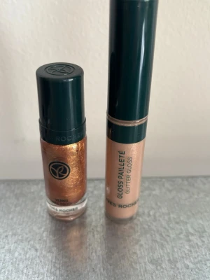 Glittrigt läppglans och nagellack från Yves Rocher - Säljer ett snyggt läppglans och nagellackfrån Yves Rocher i en skimrande, guldig-bronsig nyans. Kommer i en smidig tub med mörkgrönt lock och har en glittrig finish som ger läpparna/ansiktet extra lyster. Perfekt för dig som gillar att sticka ut med lite extra glow.