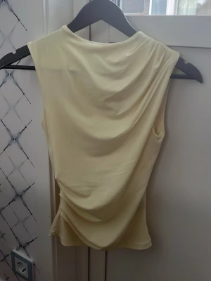Super fin gul topp  - Super fin gul topp från hm! Den har som en drapering som detalj och har en liten smink fläck vid kragen men det får bort i tvätten!!💓