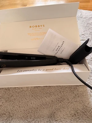 Bobbys Hair Care plattång svart - Säljer en svart plattång från Bobbys Hair Care. Kommer i originalförpackning med manual. Plattången har en stilren design och sladd för enkel användning. Perfekt för att styla håret snabbt och smidigt.