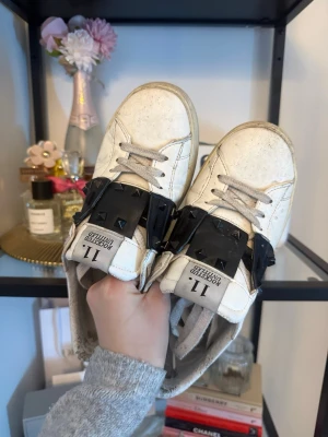 Valentino Garavani vita sneakers - Säljer ett par vita sneakers från Valentino Garavani med svarta detaljer och nitar. Dåligt skick- bra pris. Dom behöver verkligen kärlek.