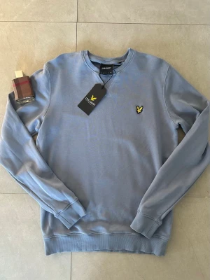 🌟 NY Lyle & Scott Sweatshirt - Storlek S (Tags kvar!) j2k grish Stockholm style Gorpcore - Säljer en jättefin ljusblå sweatshirt från Lyle & Scott Vintage i storlek Small 👕  Tröjan är helt ny och oanvänd med alla tags kvar. Färgen heter Crafted Blue och är en riktigt fräsch nyans som gör sig perfekt nu till våren och vintern 💎  Klassisk modell med den gula örnen på bröstet och fin kvalitet i tyget. Ett perfekt basplagg som passar till det mesta i garderoben ✨  Hör av dig vid frågor, jag skickar den snabbt! 📦