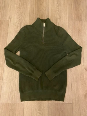 Olivgrön stickad half zip-tröja H&M - Säljer denna schyssta och stilrena halvzipen i olivgrön färg. Tröjan är hel utan några som alls difekter.                                                                    Storlek: XS (passar S)                                                                                Skick: 10/10                                                                         Nyttpris: 349kr                                                                     ❗️Kontakta mig vid minsta lilla fråga eller fler bilder❗️