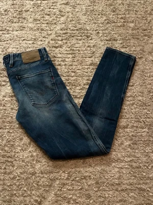 Replay Anbass jeans  - Hej jag säljer ett par Replay Anbass jeans i riktigt snygg mörkblå färg perfekt för dig som vill ha ett par kvalitetsjeans med grym passform, jeansen är även i stretch material så otroligt bekväma. Nypris ≈ 1700kr, mitt pris 399kr. Skick: 9/10 Storlek: W31L34 Midja: 43cm Lår: 24cm  Ytterlängd: 106cm Innerlängd: 80cm. Skriv gärna om du vill ha fler bilder eller har frågor!