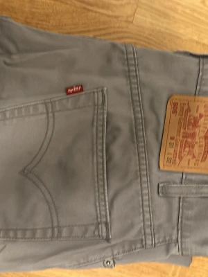 Grå Levi's jeans med rak passform - Säljer ett par gråa Levi's jeans 505 med klassisk rak passform och fem fickor. Jeansen har dragkedjegylf, bälteshällor och den ikoniska röda Levi's-lappen på bakfickan. Tillverkade i slitstarkt bomullsmaterial och har en snygg, enkel look. Dm:a gärna för fler bilder💯 W31 L32
