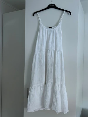Vit sommarklänning från Gina Tricot - Luftig vit klänning med smala axelband från Gina Tricot. Klänningen har en lös passform. Perfekt för varma dagar, exempelvis som en strandklänning eller på en skolavslutning! Endast använd ett fåtal gånger. Skriv gärna privat vid fler frågor! 💓
