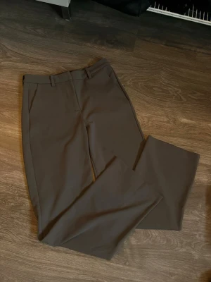 Gråa kostymbyxor med raka ben - Gråa kostymbyxor från Vero Moda, två fläckar som nog går bort i tvätten om man försöker få bort de me tex vanish eller diskmedel. Lite slitna o noppriga som går att ta bort 