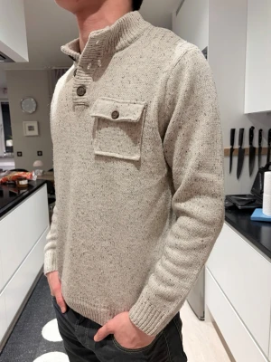 Beige stickad tröja - Saljer denna skitsnygga stickade tröjan med knappkrage och en bröstficka. Sjukt snygg nu till våren med sin ljusare färg. Ett plagg för dig som gillar vintage stil och vill ha nåt snyggt stickad till din garderob. Hör av dig 