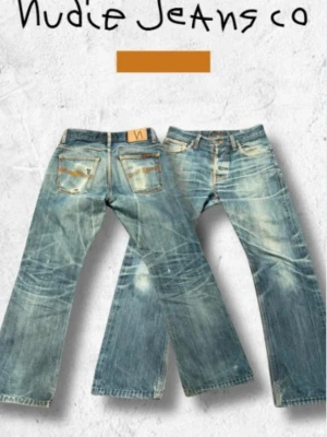 Nudie Jeans Regular Alf - Dry Red Selvedge  - Här har du en riktig svensk denimklassiker. Modellen Regular Alf var en av de absoluta storsäljarna under Nudie Jeans tidiga år i Göteborg och representerar märkets rötter i hållbar rådenim, jeansen har en bootcut/loose/straight. Den slutade tillverkas för över ett decennium sedan, vilket gör ett par i det här skicket till ett fynd för den som söker äkta vintage. Passformen är rak och tidlös. På lappen står det W29 L32 men gå efter mått istället. Passar dig som är runt 170. Midjan mäter 38 cm! 