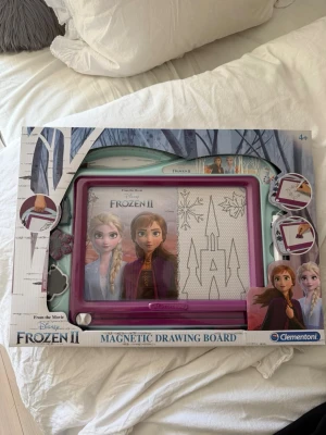 Frozen II magnetisk ritplatta  - Magnetisk ritplatta med motiv från Disney Frozen II. Plattan är lila med vit rityta och har illustrationer av karaktärer från filmen på förpackningen. Perfekt för kreativa stunder och enkel att använda om och om igen.