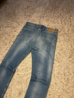 Replay anbass jeans slim fit herr w32 - Replay anbass jeans i slim passform. Storlek W32. Skön wash o små slitningar. Mycket bra skick övrigt, förutom defekt på baksidan, se bilder, inget stort. Postas samma dag som köp eller dagen därpå🙌💯