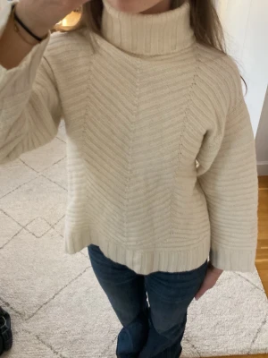 Vit stickad polotröja - Säljer en beige/benvit stickad polotröja med bred ribbstickad krage