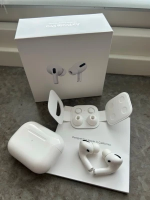 AirPods Pro 2 - Säljer mina AirPods Pro 2 från Apple. Väldigt bra skick och sparsamt använda. Fabriksåterställda.   ✔️ Allt är noggrant och kliniskt rengjort ✔️ Originalkartong medföljer ✔️ Oanvända silikonproppar i storlek L ingår ✔️ Superfint skick utan större slitage  ⚠️ Observera: Högra airpoden kan ibland ha problem med noise canceling, kan brusa ibland. Utöver det fungerar de felfritt.   Fodralet har en lätt missfärgning på insidan, men inget som påverkar funktion (se sista bilden).