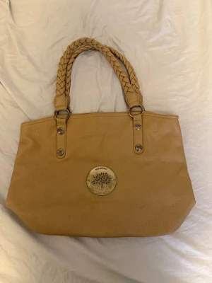 ÄKTA Mulberry väska  - Mulberry-väska säljes till mycket bra pris.  Väskan är använd och har visst slitage, men är fortfarande i fint skick och fullt användbar. Perfekt för dig som vill ha en äkta Mulberry till ett betydligt lägre pris än nypris – de billigaste modellerna ligger runt 10 000 kr i butik.
