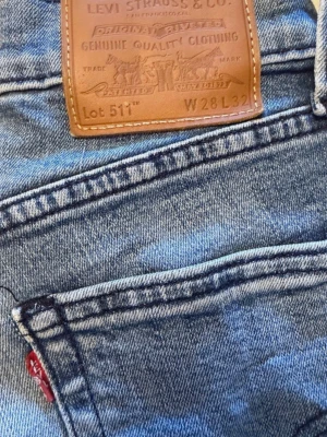 Levis jeans w28 L32 - Ett par jeans från Levi's i modellen 511. Jeansen har en klassisk design med fem fickor och gylf med knappar. Passar bra för en avslappnad stil. Rökfritt hem