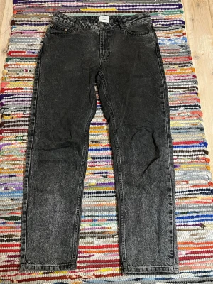 Svarta jeans med tvättad look - Sjukt feta svarta jeans med en fet tvättad finish och raka ben i storlek W28 och L30. Klassisk femficksmodell och hög midja. Perfekta för en avslappnad och trendig stil. Från märket Grunt!