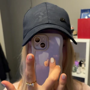 Mörkblå Nike keps med böjd skärm - Snygg mörkblå keps från Nike med klassisk böjd skärm och diskret Nike-logga på framsidan. Kepsen har ventilerande hål och justerbar passform. Insidan är dekorerad med Nike-loggor längs sömmarna. Perfekt för en sportig och avslappnad stil.