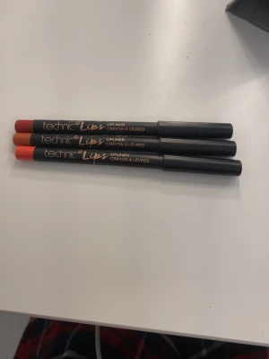 Technic läppennor i tre färger - Säljer tre läppennor från Technic i snygga nyanser: röd, orange och mörkröd. Pennorna har svart hylsa och klassisk pennform, perfekta för att definiera och fylla i läpparna. Smidig att använda och lätt att ta med i väskan.