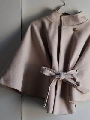Beige cape-rock med knytband - Cape-kappa från MISSÄY. Knappt använd, från sommar 2025. Nypris 600kr