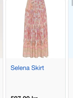 Selena långkjol med blommigt mönster - Superfin långkjol från Selena med blommigt och paisley-inspirerat mönster i rosa, beige och orange toner. Kjolen har en luftig och flowy passform, perfekt för varma dagar. Materialet känns lätt och bekvämt mot huden. Perfekt inför sommaren!