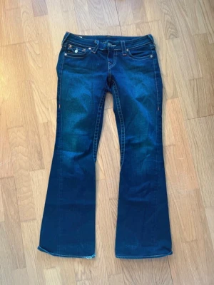  bootcut jeans True Religion - Säljer ett par mörkblå low waist bootcut jeans från True Religion. Midjemått tvärs över och Innerbenslängd syns på bilderna . Hör av er vid frågor. Pris kan diskuteras vid snabb affär
